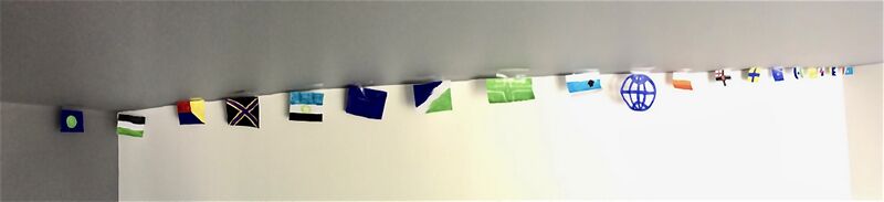 File:Micronational flags hang up on a wall for Zabëlle's 1 Year Microversary.jpeg