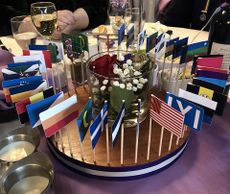 Centerpiece at a dinner table, showing multiple flags from attending nations